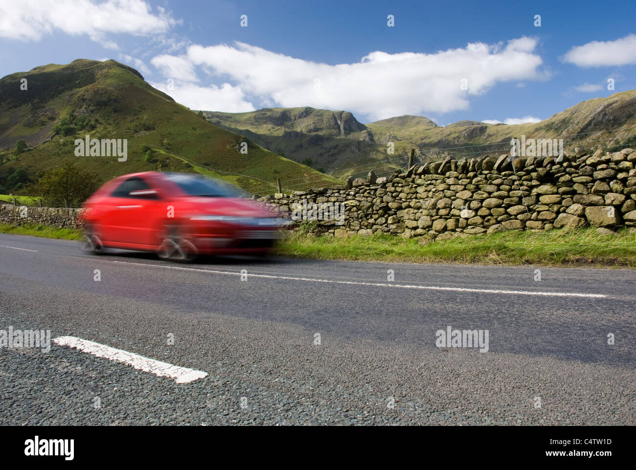 Speeding red car, Road A592, Lake District National Park, UK Stock Photo