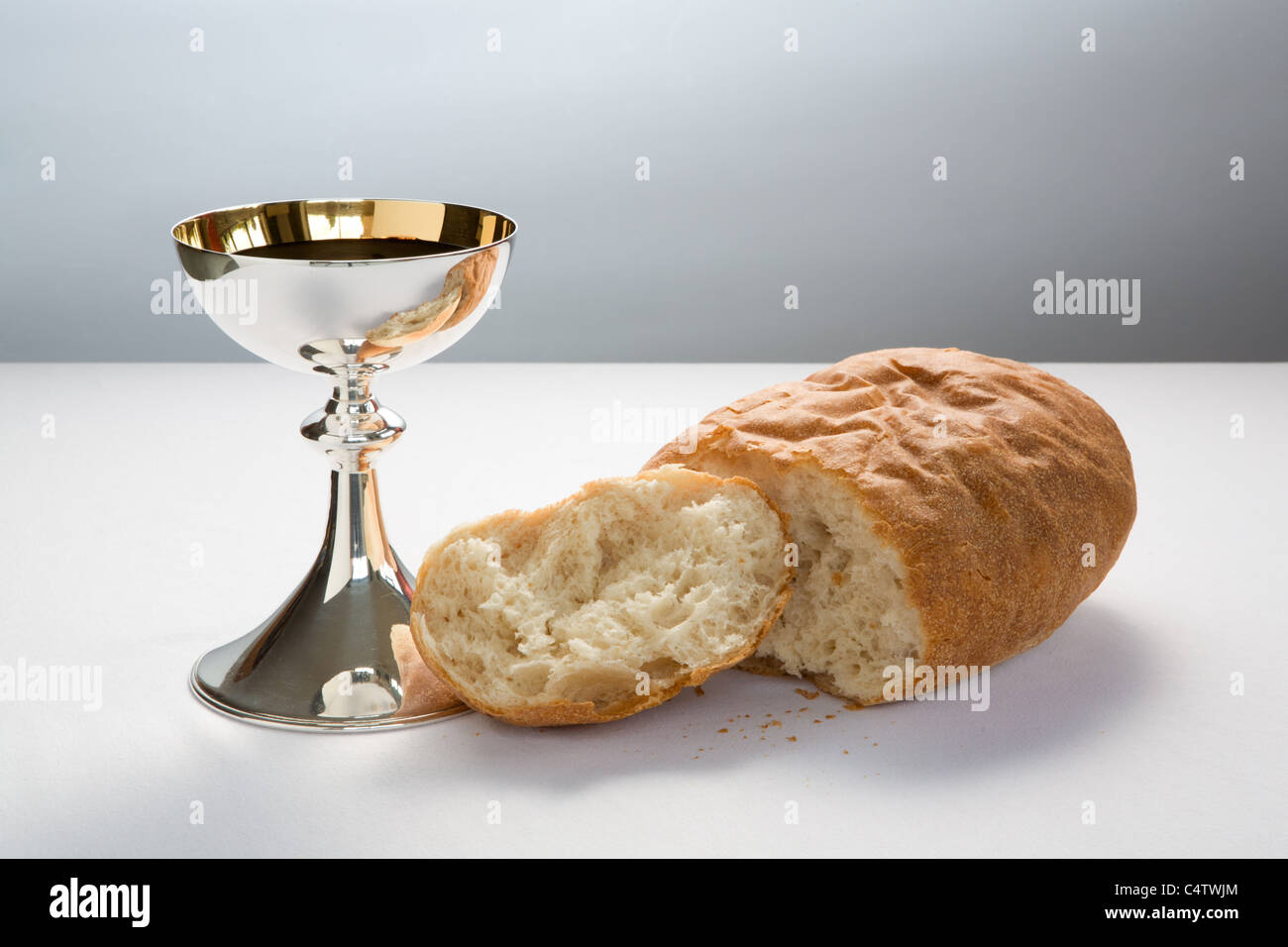 Holy Communion cup (chalice) with wine and broken loaf of bread, for celebration of Christian