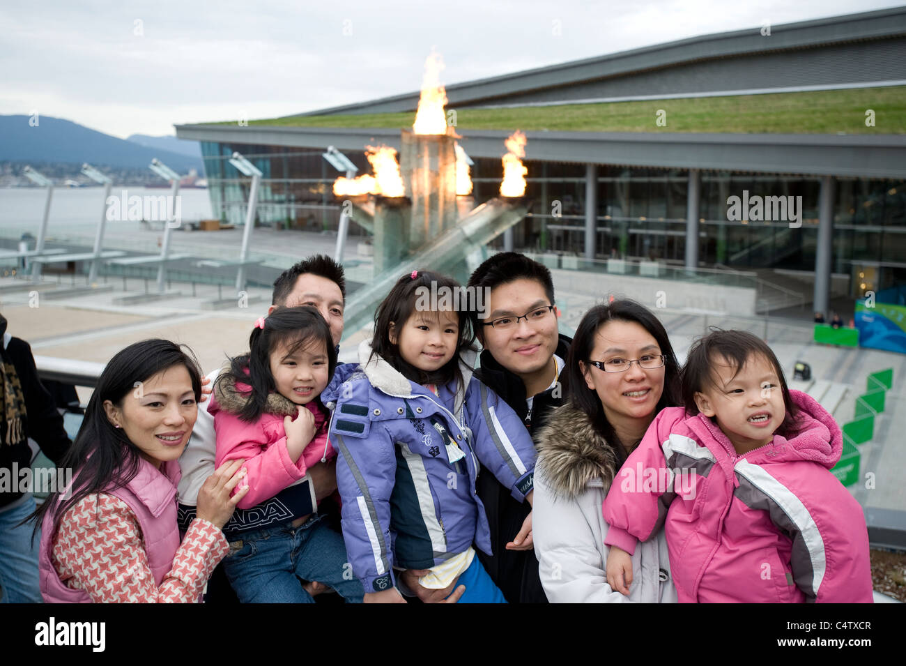 Two Chinese families with children by the Olympic torch in Vancouver Stock Photo