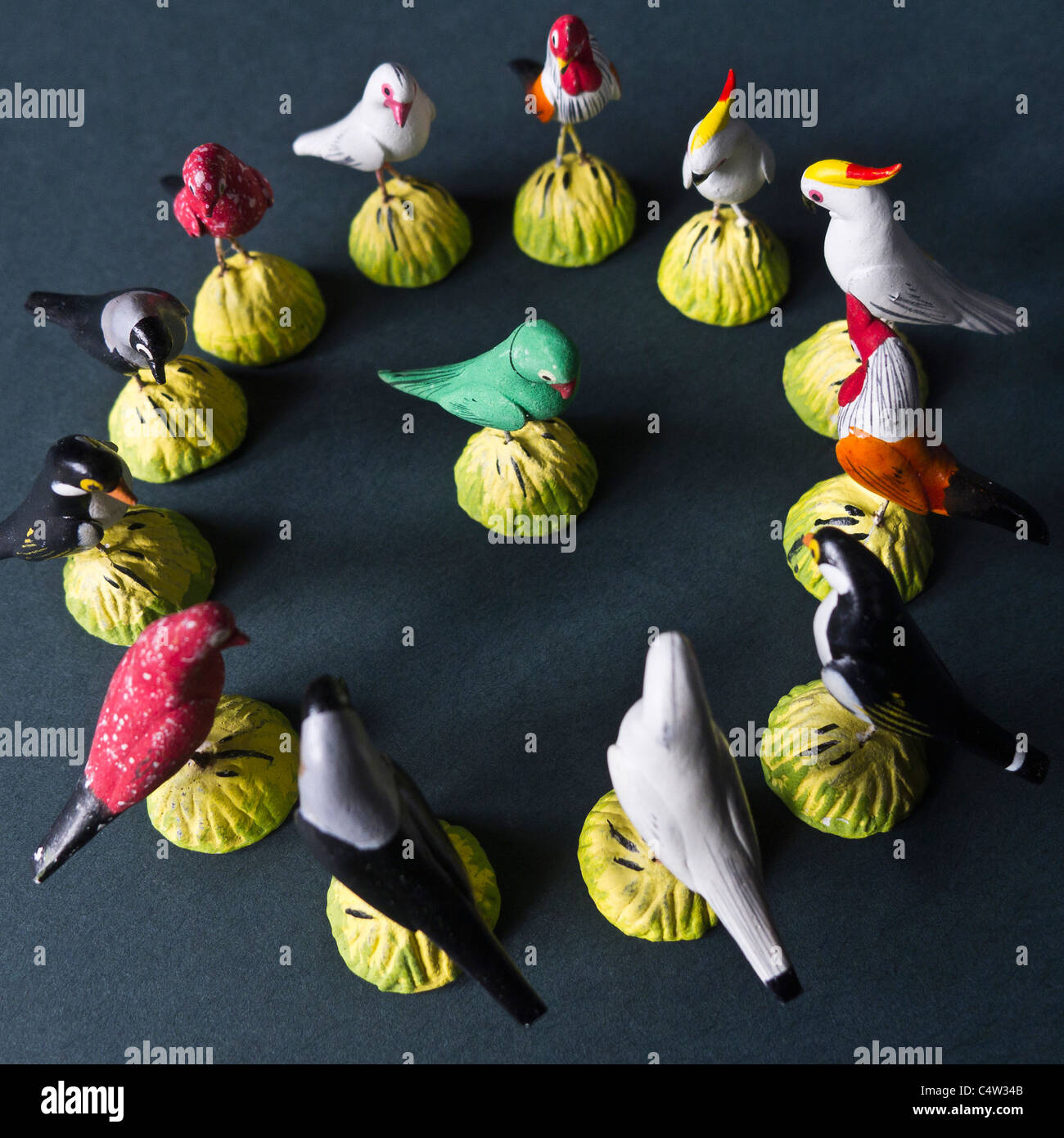 Miniature models of birds arranged in a circle with one in the centre. Stock Photo