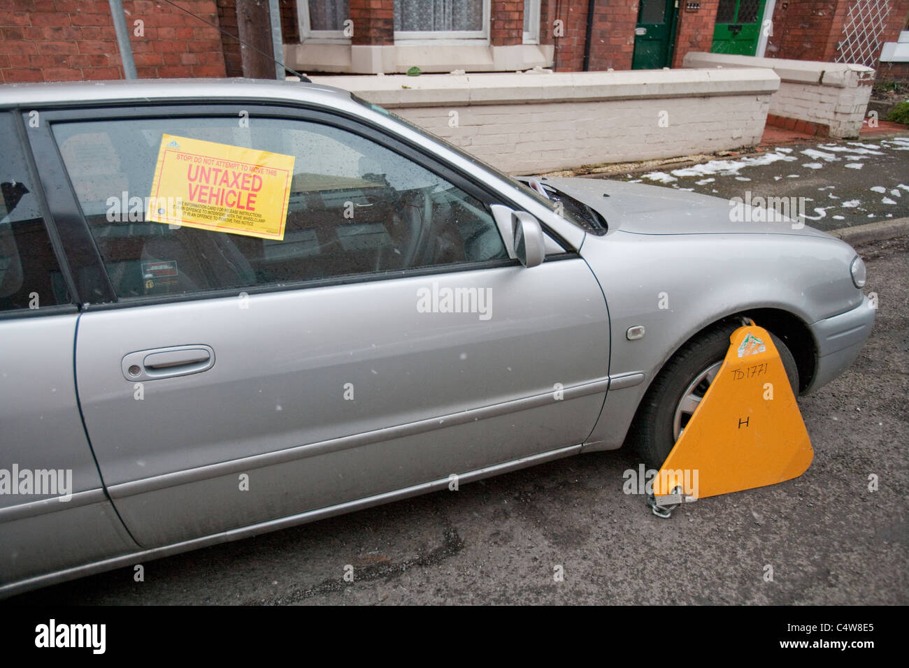 Untaxed Car clamped by the DVLA,Untaxed vehicle wheel clamped Stock Photo