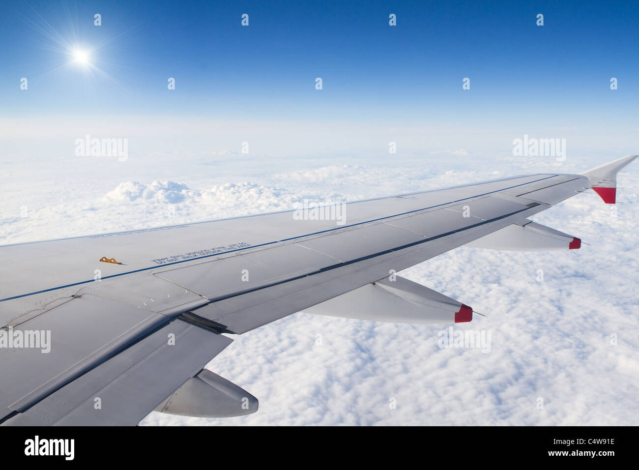 Airplane wing above the fluffy white clouds Stock Photo - Alamy