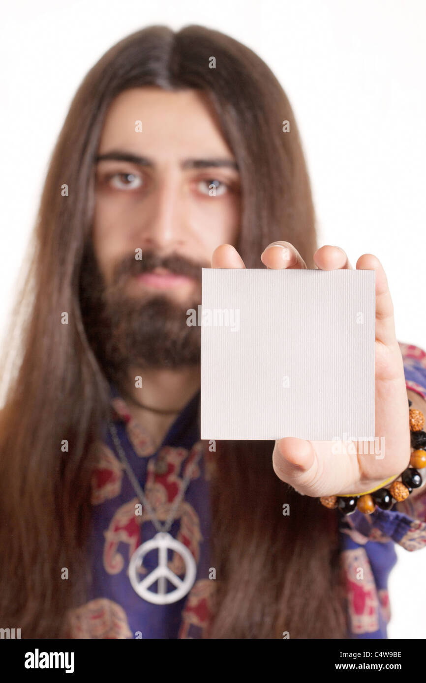 Long-haired hippy man holding blank paper card Stock Photo