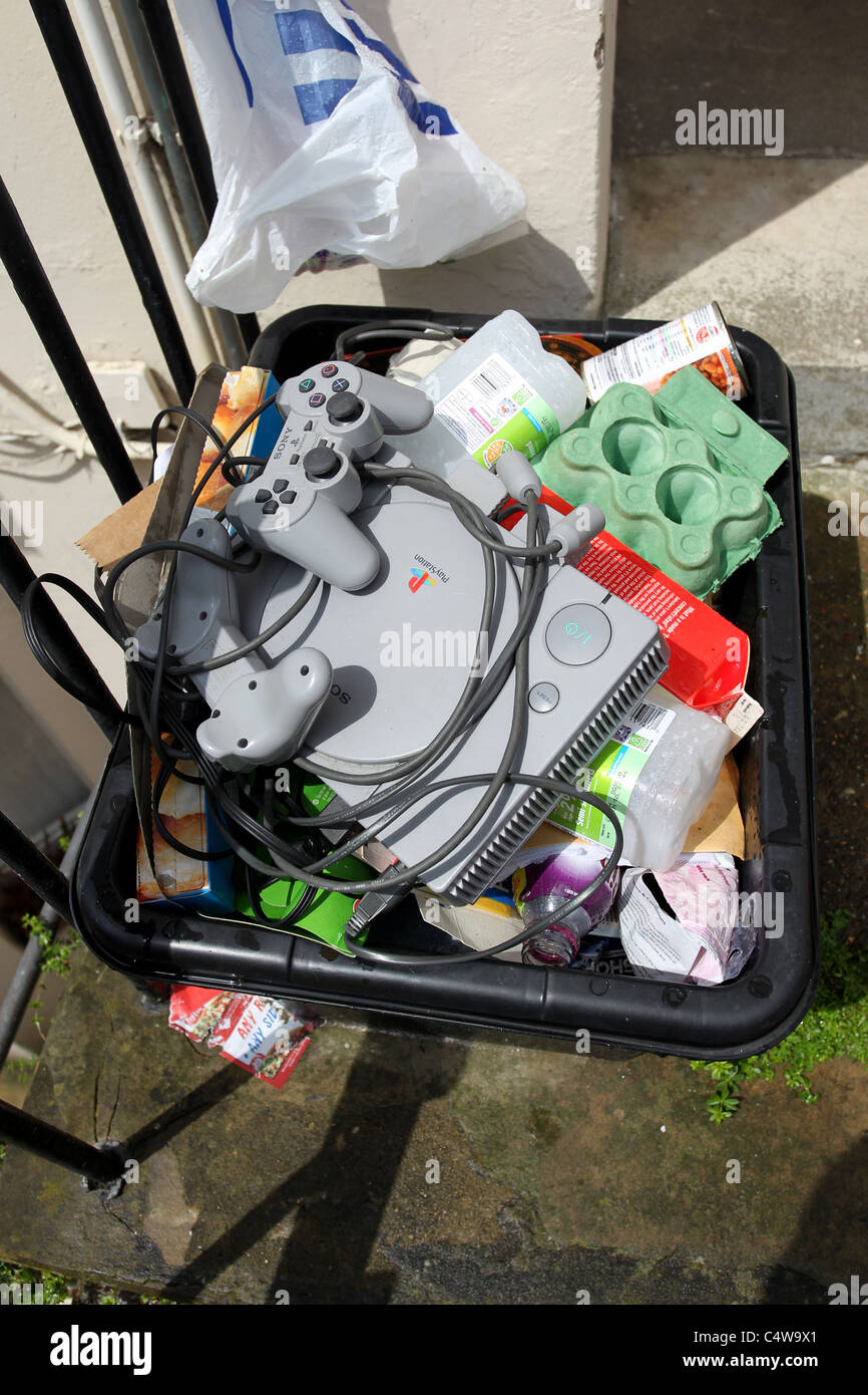 An old Sony Playstation One pictured in a bin in Brighton, East Sussex, UK. Stock Photo