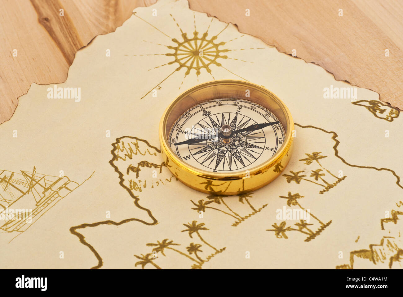 ein Kompass liegt auf einer alten Schatzkarte | a compass lies on an old treasure map Stock Photo