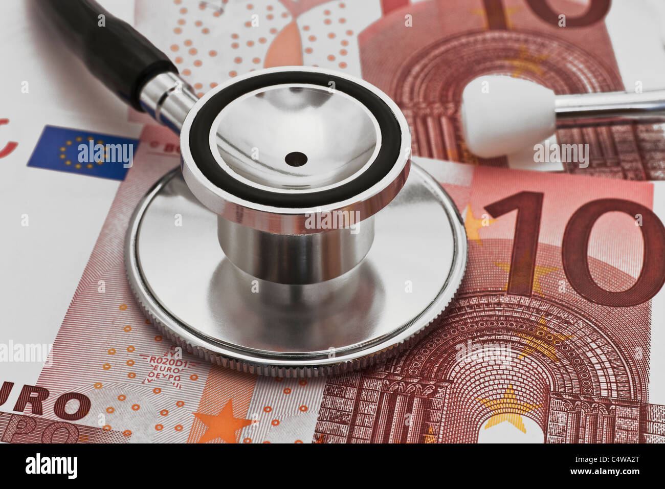 ein Stethoskop liegt auf mehreren zehn Euro Scheinen | some ten euro banknotes, a stethoscope is on it Stock Photo