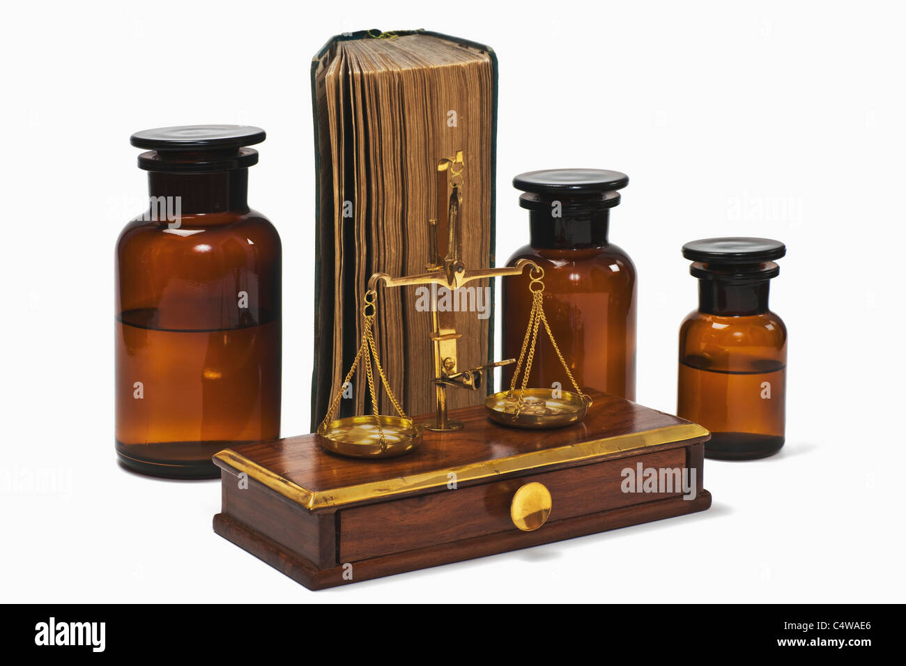 Detail photo of a old druggist balance alongside are three pharmacists bottles and a old book Stock Photo