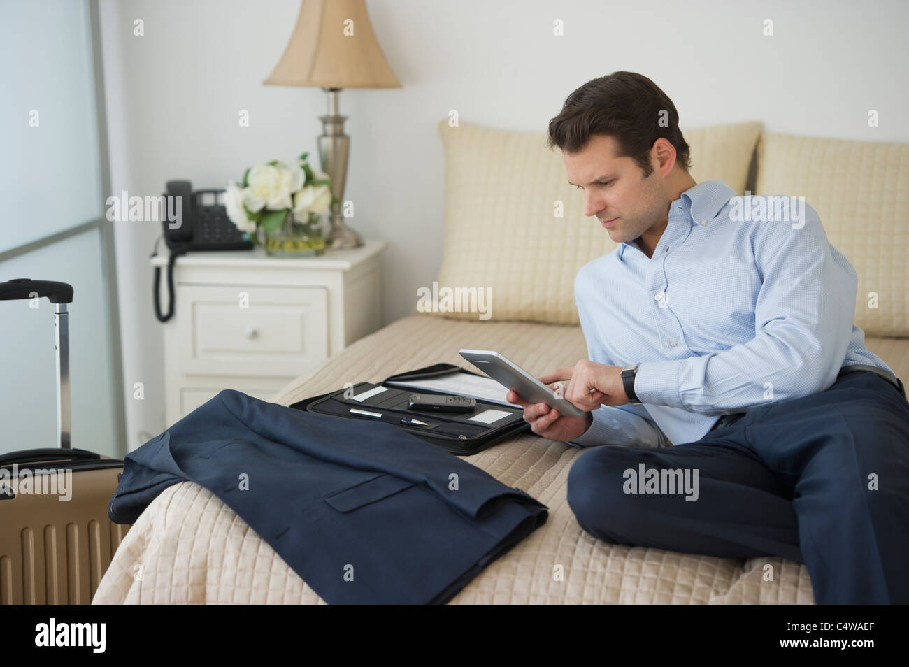 USA,New Jersey,Jersey City,businessman using digital tablet in hotel room Stock Photo