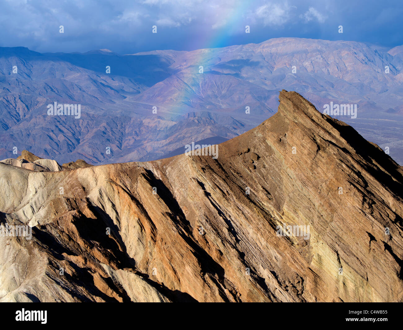 Rainbow, storm and rock formations as seen from Golden Canyon Trail. Death Valley National Park, California Stock Photo
