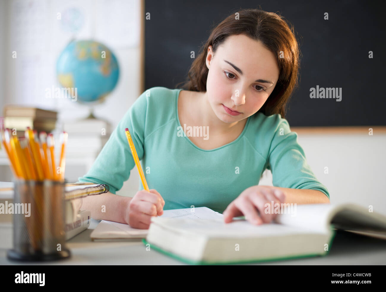 USA,New Jersey,Jersey City,Teenage girl (14-15) doing homework Stock Photo