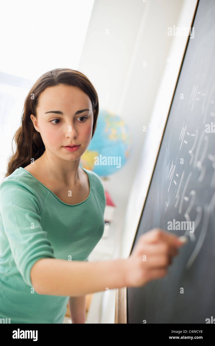 USA,New Jersey,Jersey City,Teenage girl (14-15) writing on blackboard Stock Photo