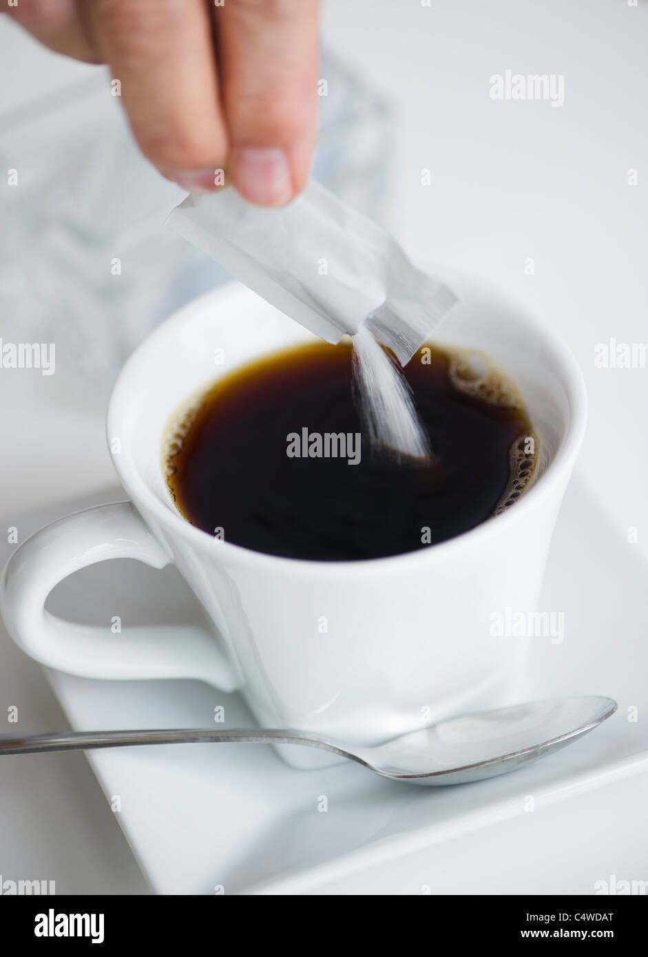 Man pouring sweetener into coffee Stock Photo