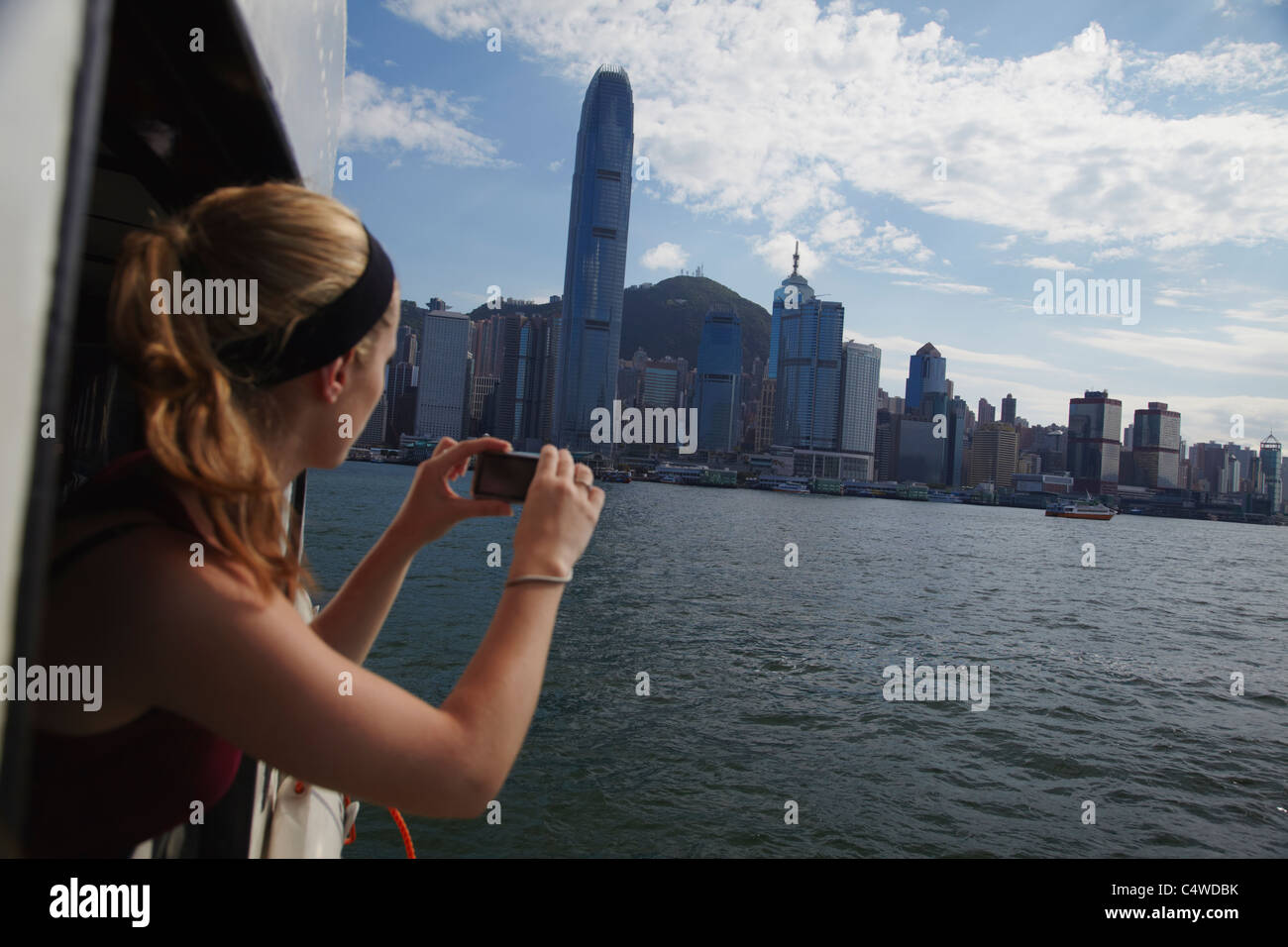 Woman taking photo of Hong Kong skyline from Star Ferry, Hong Kong ...