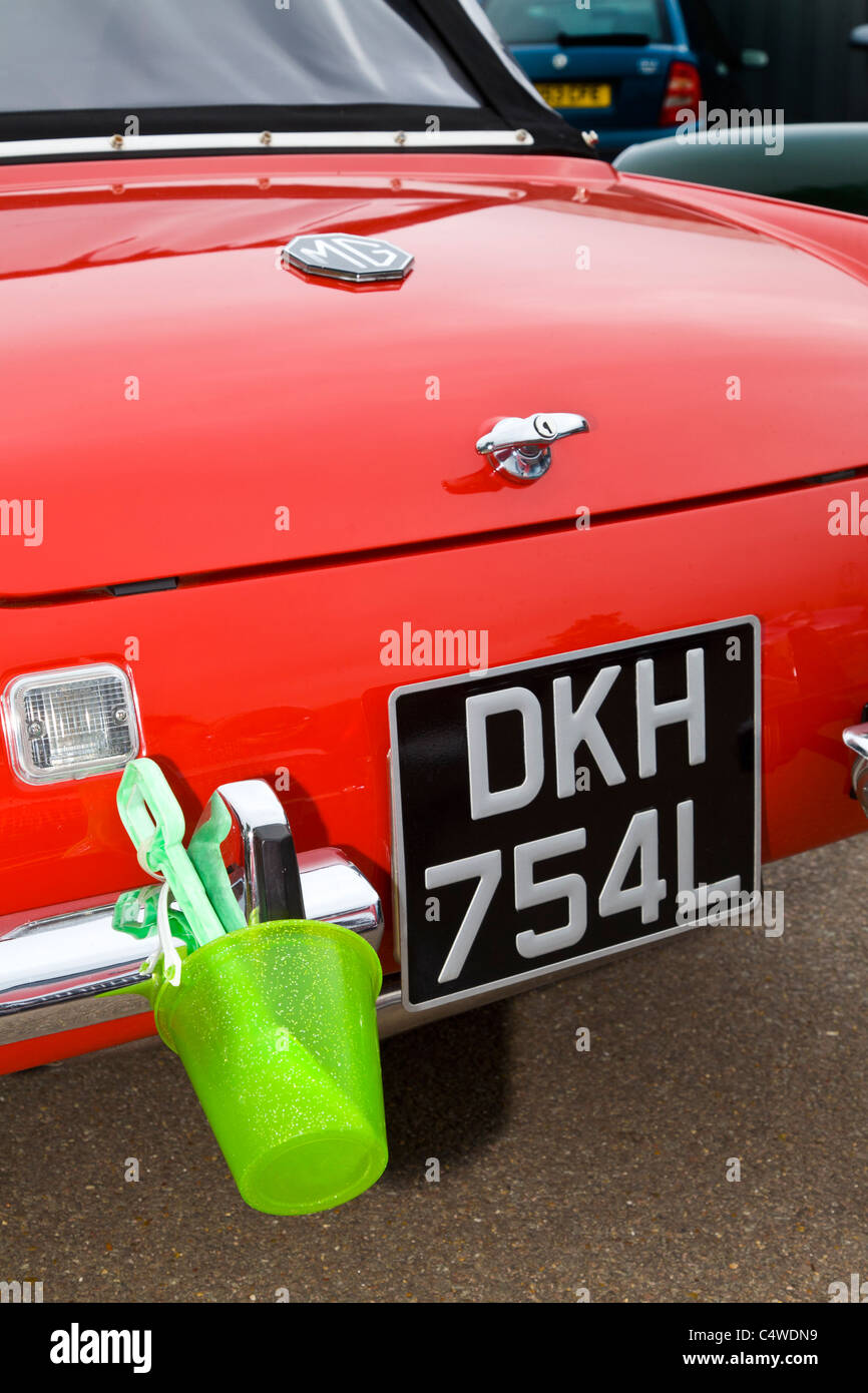 Rear end of a 1972 MG Midget with child's bucket and spade. Midget and Sprite Club Norfolk Tour, Aylsham, England, UK. Stock Photo