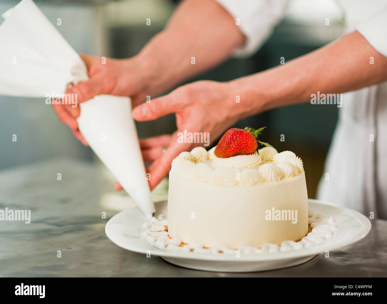 USA, New York State, New York City, Pastry chef decorating cake Stock Photo