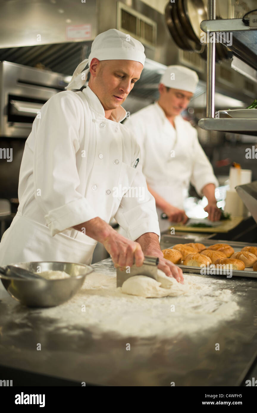 USA,New York State,New York City,Chef cutting pastry to make rolls Stock Photo
