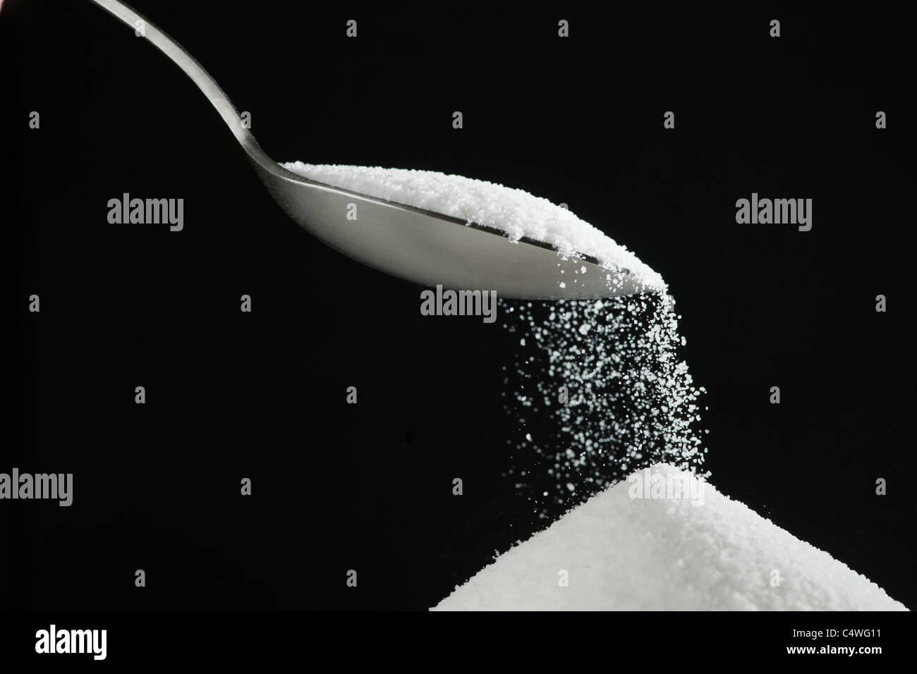 Spoon and heap of sugar Stock Photo