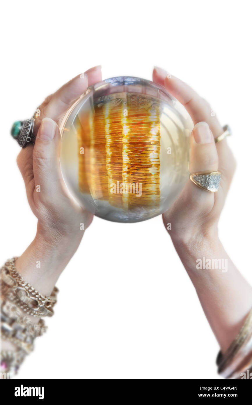 woman's hands holding crystal ball and divining a prosperous future. High key. Stock Photo