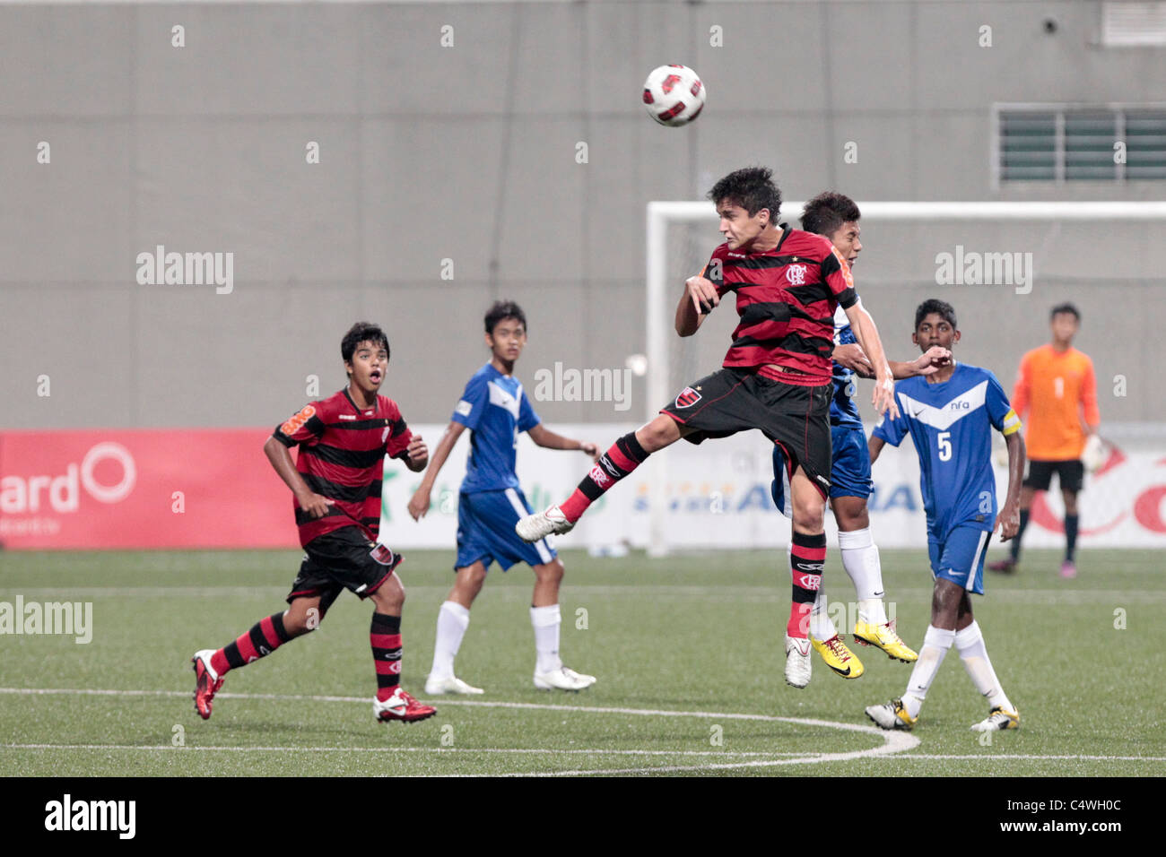 Joao Cancellieri of CR Flamengo U15 and Mahathir Azeman goes up for the aerial challenge during the 23rd Canon Lion City Cup. Stock Photo