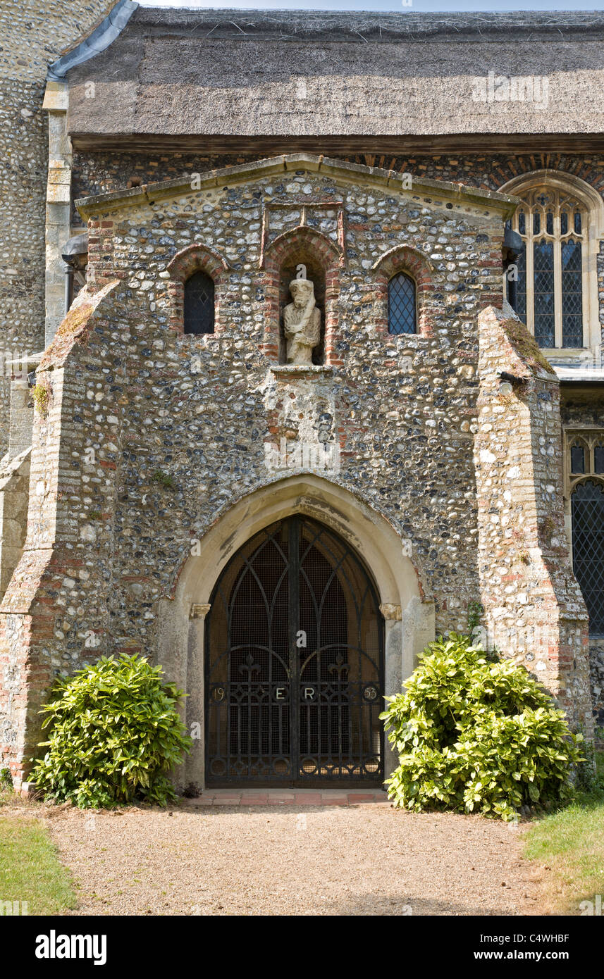 The entrance porch to St Nicholas church, Potter Heigham, Norfolk. Gated entrance fitted in 1953 and marked ER, Elizabeth Regina Stock Photo