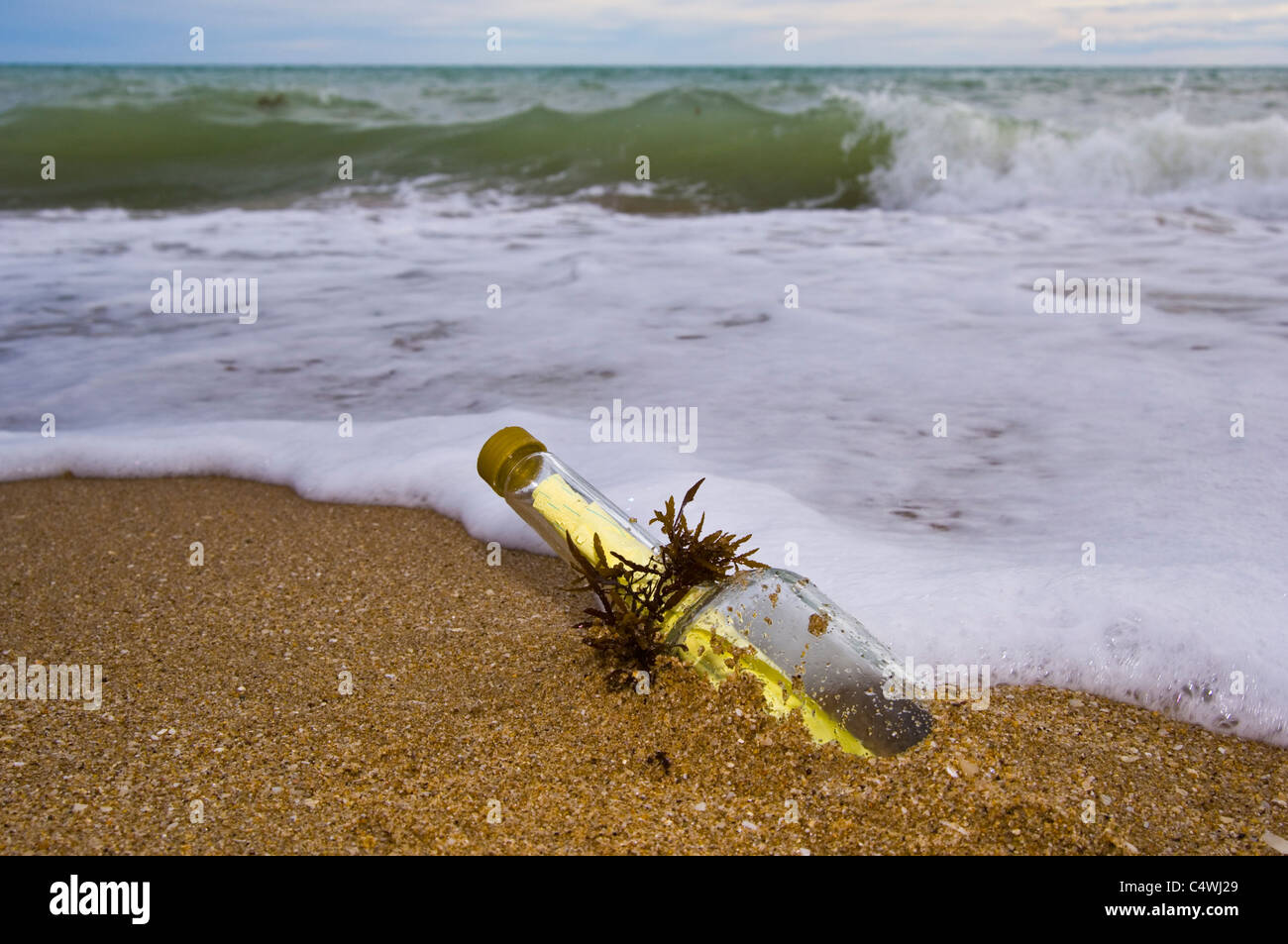 Glass bottle with note from some one lost at sea or stuck on an island. Stock Photo