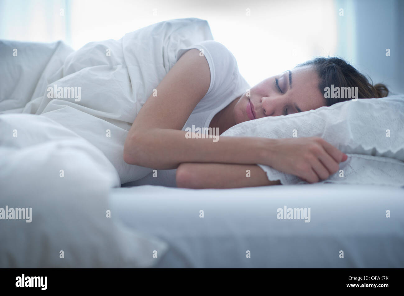 USA, New Jersey, Jersey City, Happy young woman sleeping in bed Stock