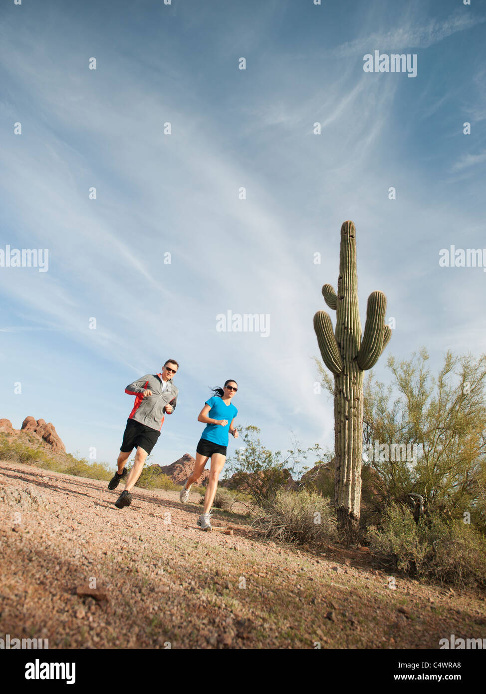 USA, Arizona, Phoenix, Mid adult man and young woman jogging on desert Stock Photo