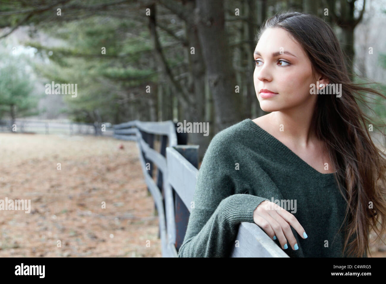 USA, New Jersey, Califon, Teenage girl (16-17) standing near fence and looking away, portrait Stock Photo