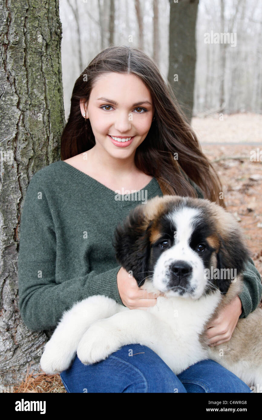 USA, New Jersey, Califon, Teenage girl (16-17) sitting with Saint Bernard puppy on laps, portrait Stock Photo