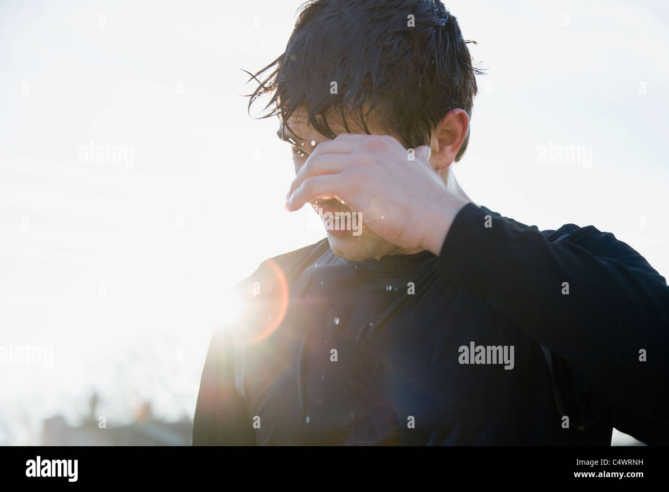 USA, Michigan, man in sports clothing back lit by sun Stock Photo