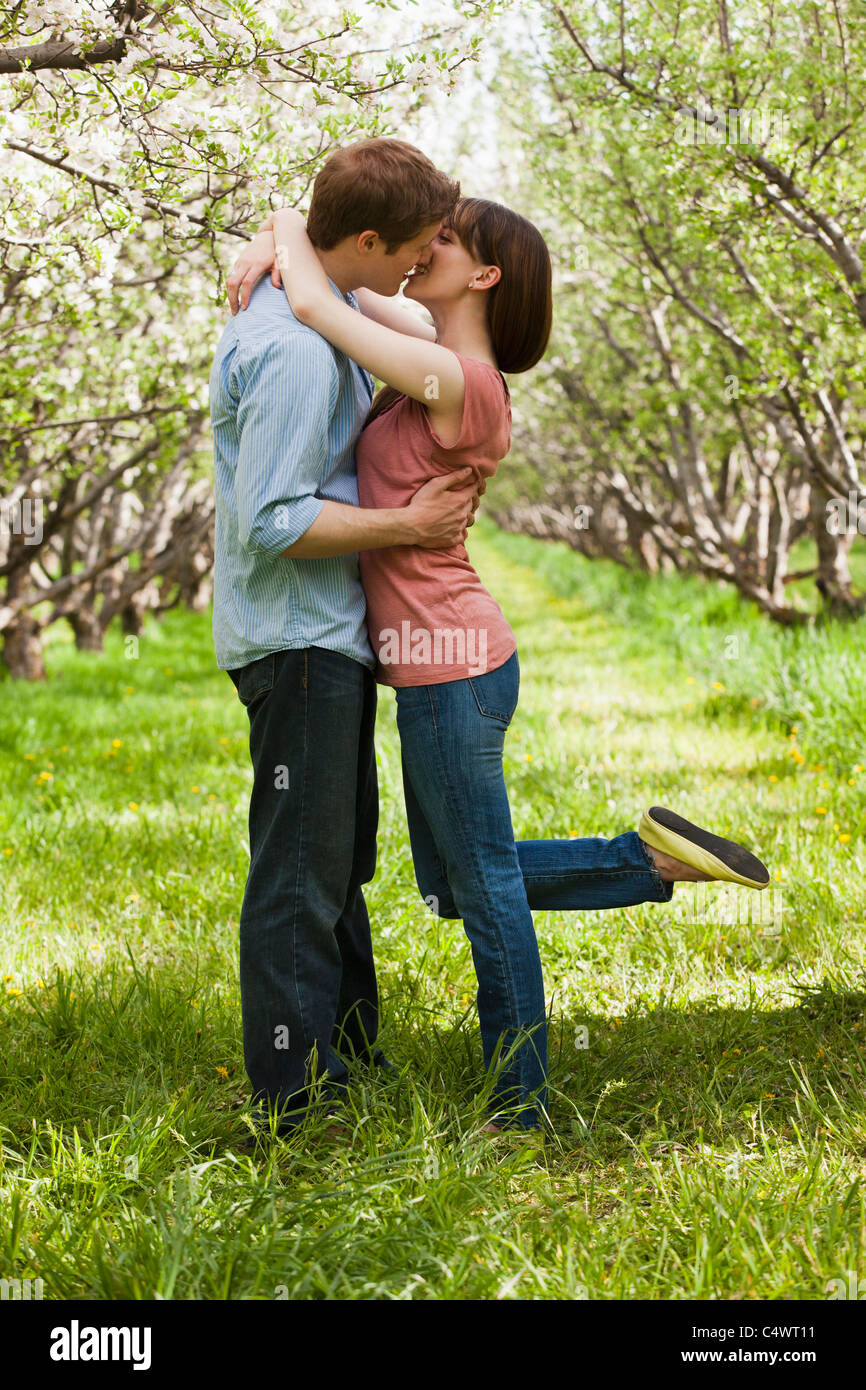 USA,Utah,Provo,Young couple kissing in orchard Stock Photo