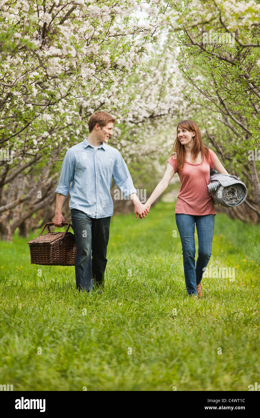 USA,Utah,Provo,Young couple with picnic basket in orchard Stock Photo