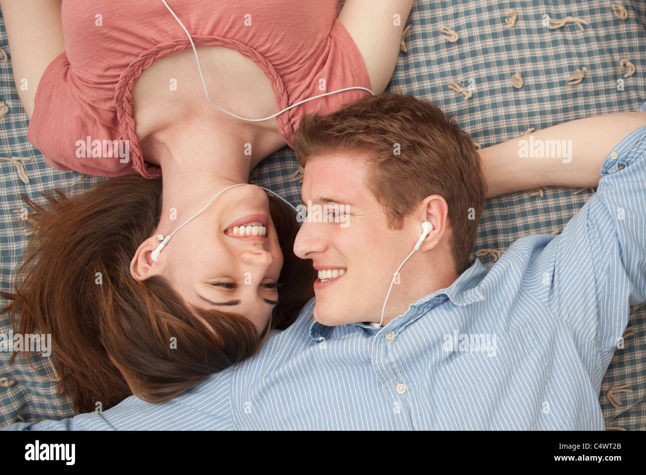 USA,Utah,Provo,Young couple with mp3 player lying on blanket Stock Photo