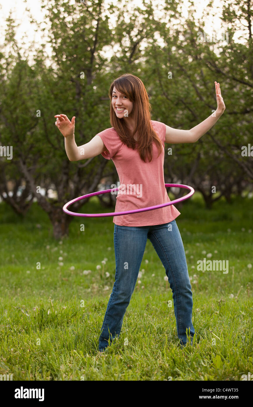 USA,Utah,Provo,Young woman using plastic hoop in orchard Stock Photo