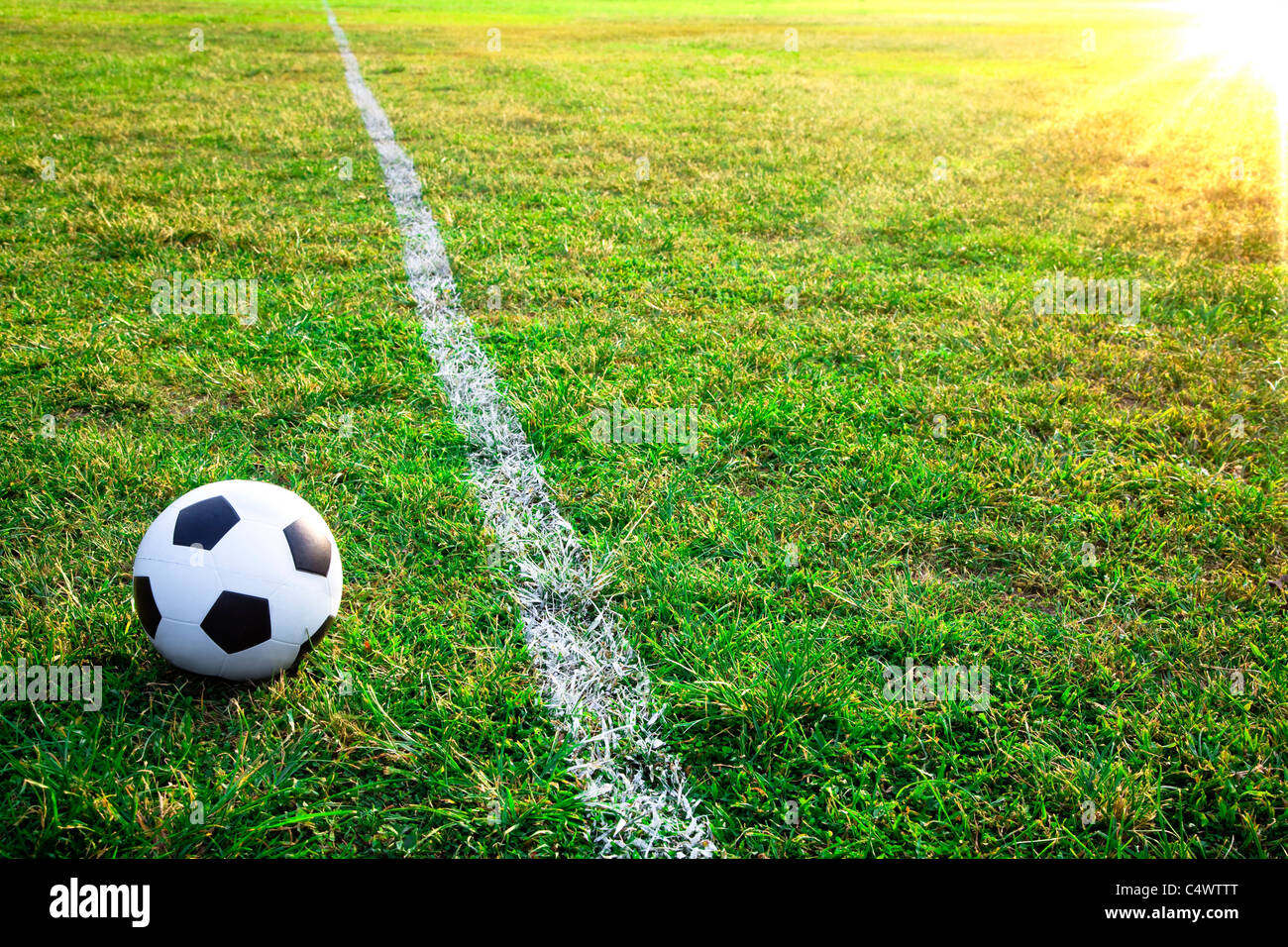 a soccer ball or football  in stadium with sunset Stock Photo