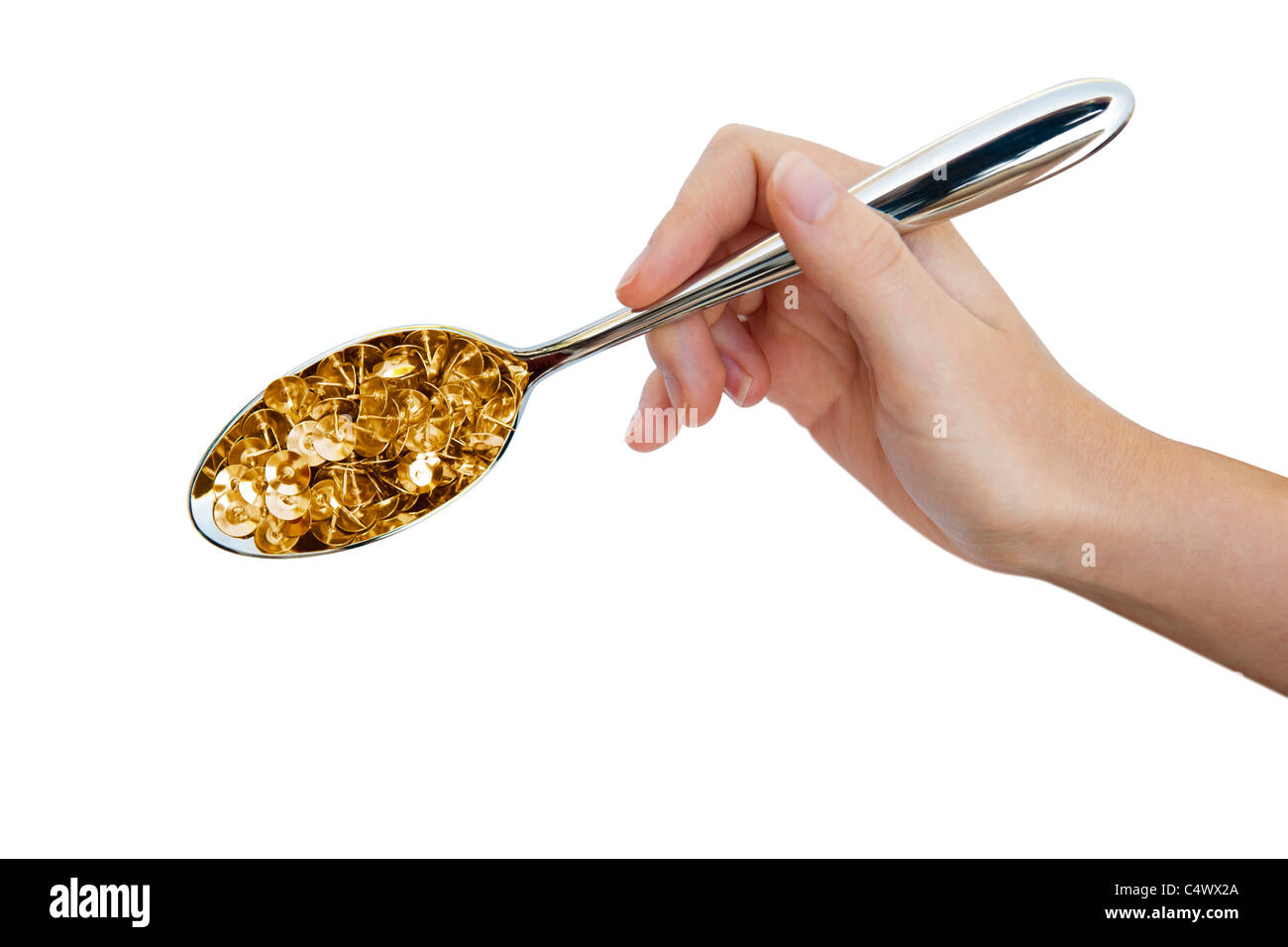 Hand holds a spoon containing drawing pins as an illustration of the effects of a food allergy Stock Photo