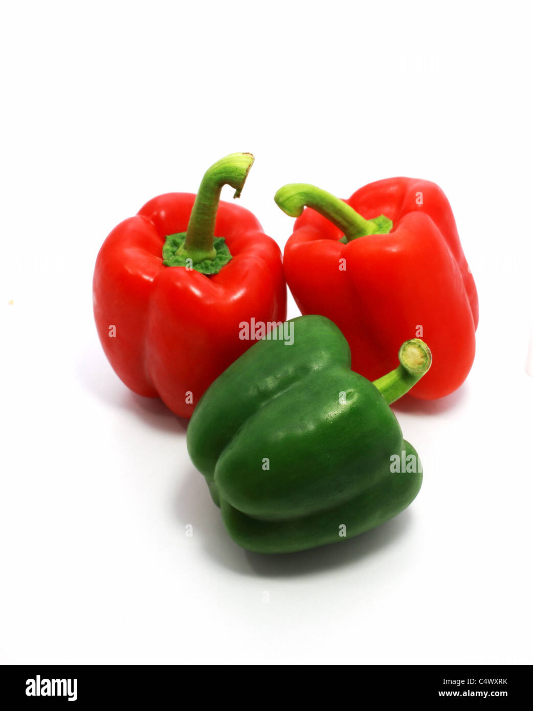 two red and one green sweet peppers isolated on white Stock Photo - Alamy