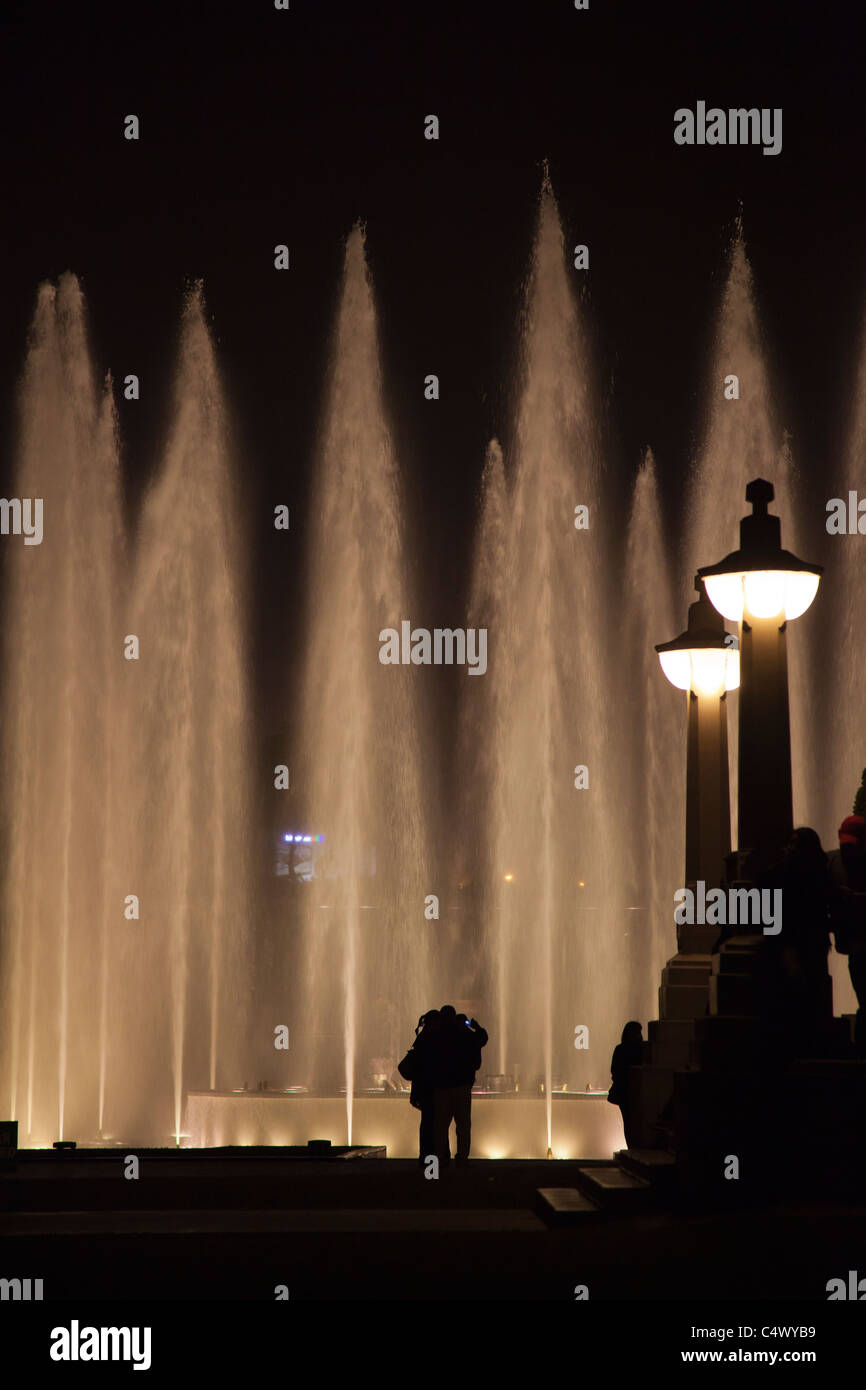 Visitors silhouetted in front of the fountains and light show at Parque de la Reserva, Lima, Peru Stock Photo