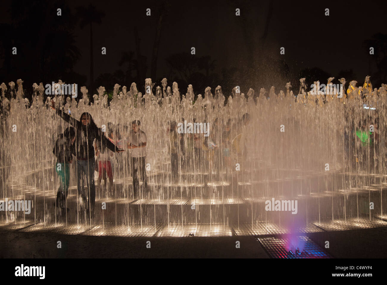 Teenagers posing for photos in the fountains and light show at Parque de la Reserva, Lima, Peru Stock Photo