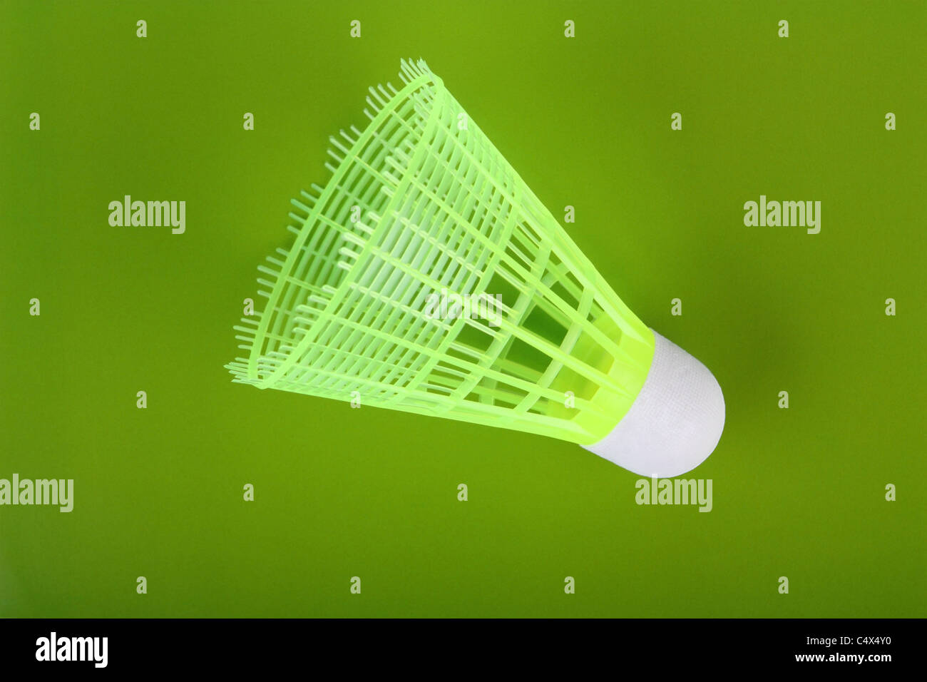 One yellow badminton shuttlecock on a green background Stock Photo