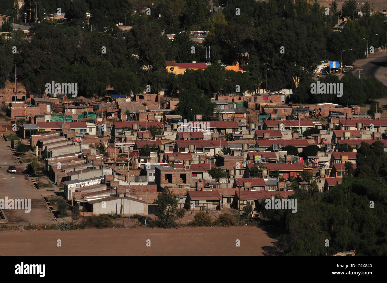 Zoom shot, looking down from Cerro Gloria, of suburban red brick homes in the south-western outskirts of Mendoza, Argentina Stock Photo