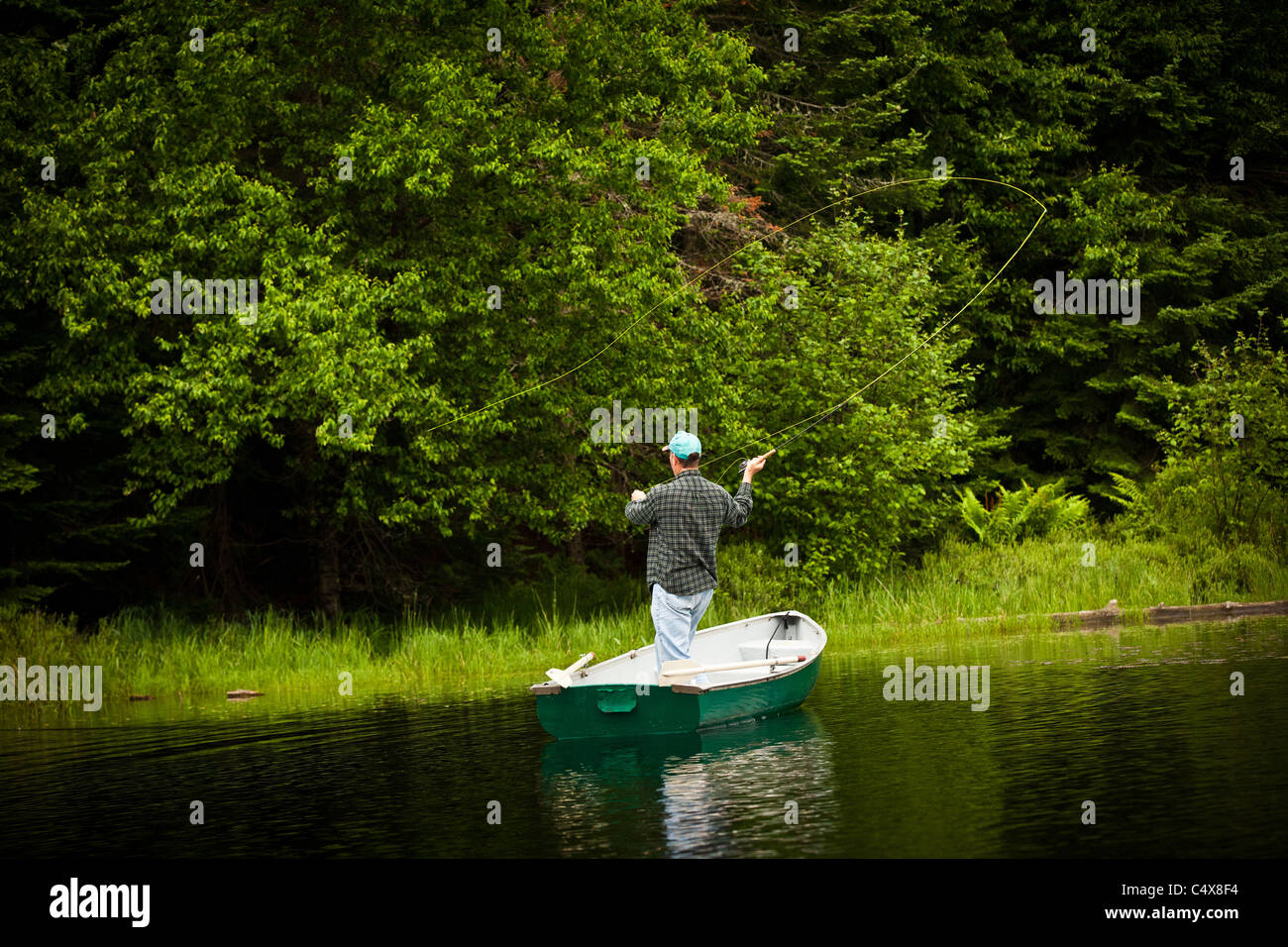 A man fly casts trout on a lake in Boulder Junction, Wisconsin Stock