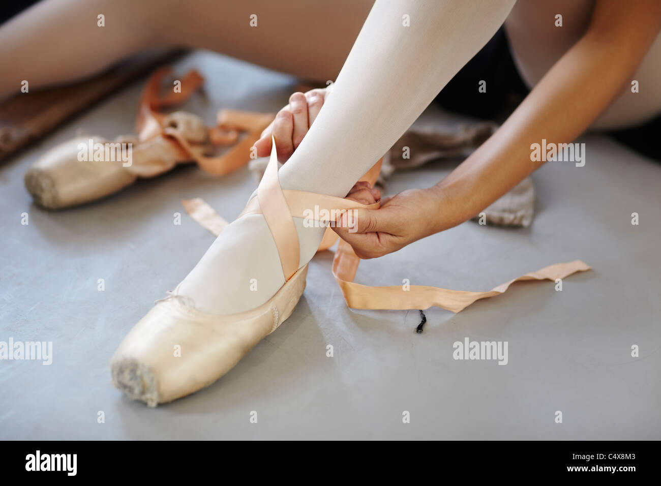 Female ballet dancer adjusting laces on her shoes Stock Photo