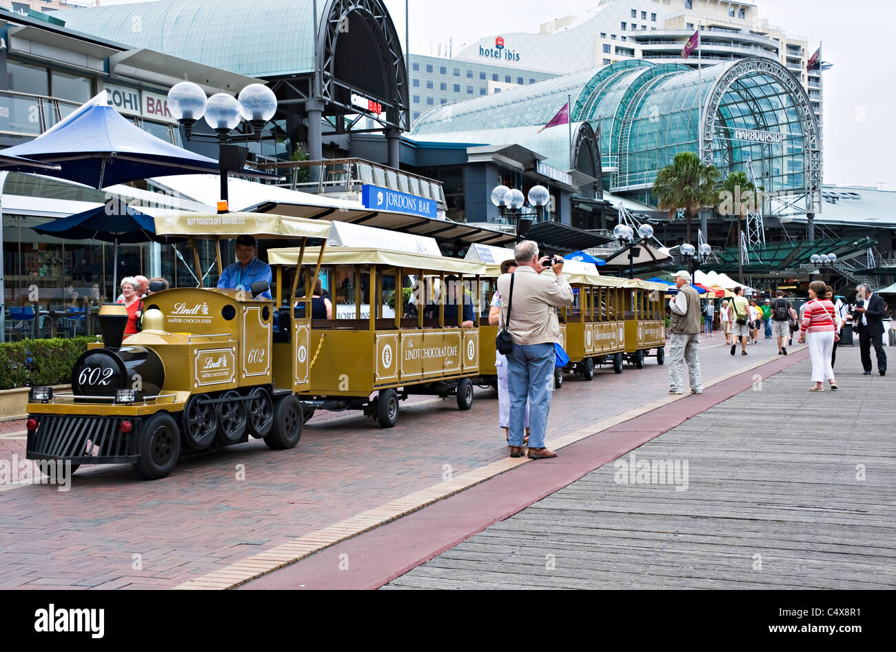 Harbourside Promenade Entrance and Large Paved Forecourt with Tourist Train at Darling Harbour Sydney New South Wales Australia Stock Photo