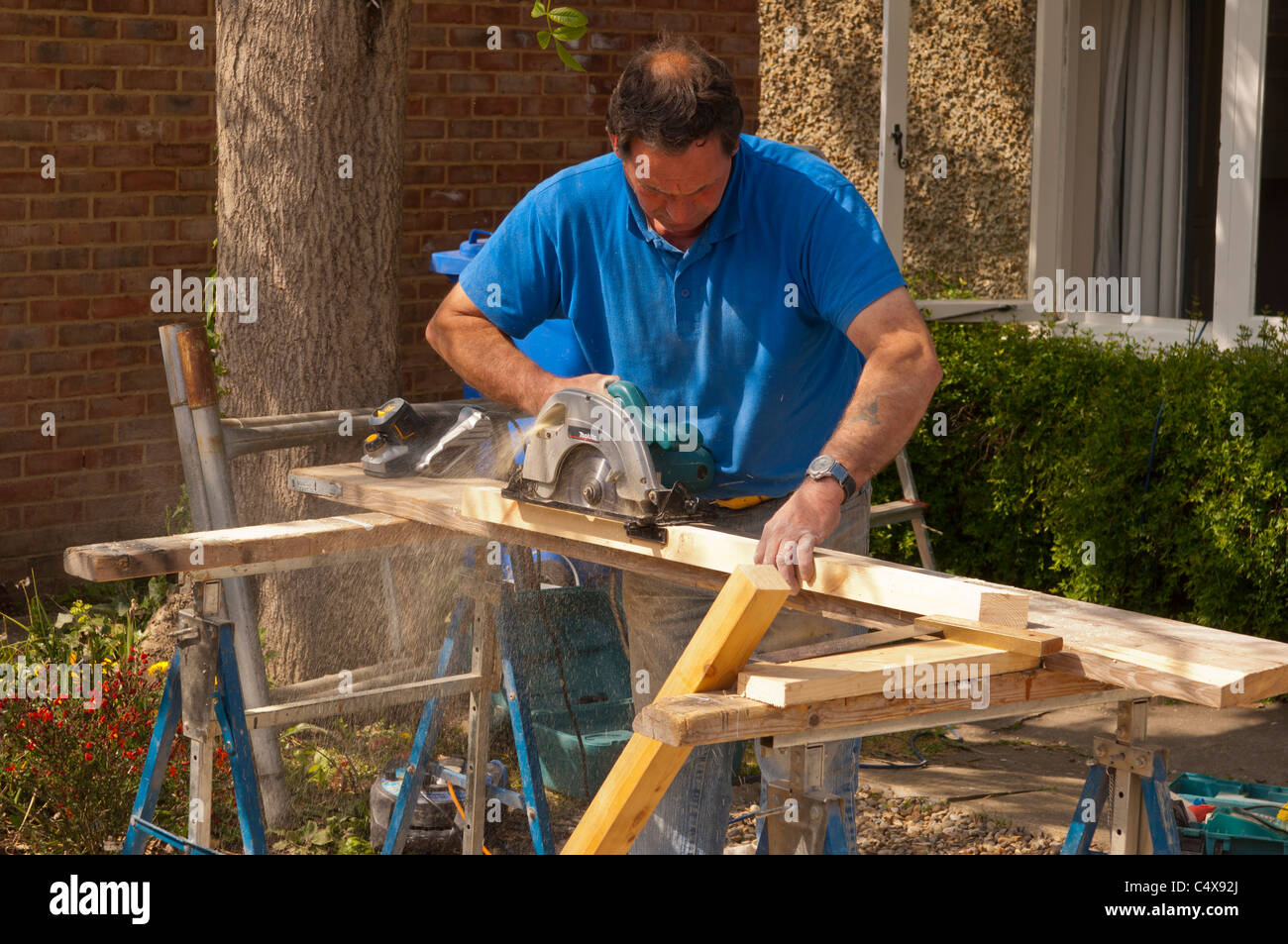 Planing a bit of wood with an electric planer hires stock photography
