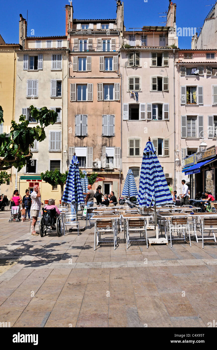The tables and chairs of a charming outdoor brasserie waiting to be filled with customers in Place Louis Blanc, Toulon, France Stock Photo