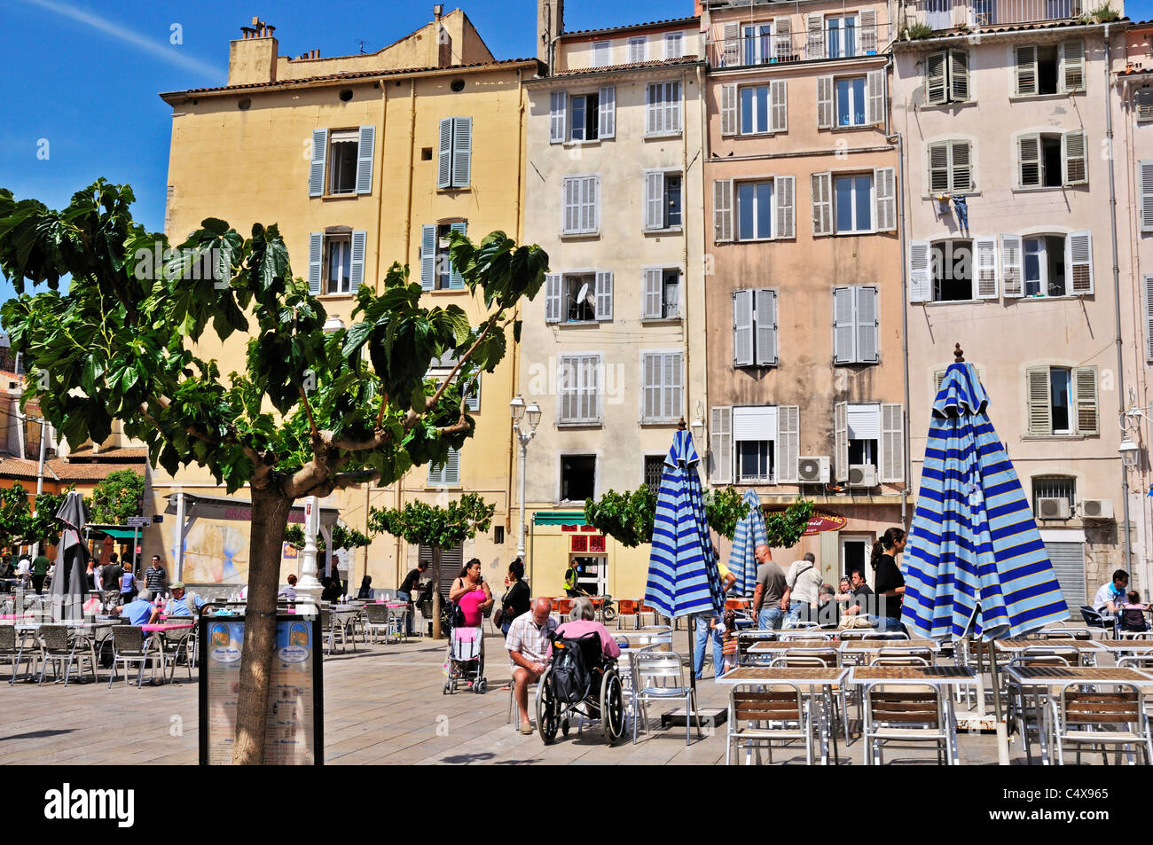 The tables and chairs of a charming outdoor brasseries waiting to be filled with customers in Place Louis Blanc, Toulon, France Stock Photo