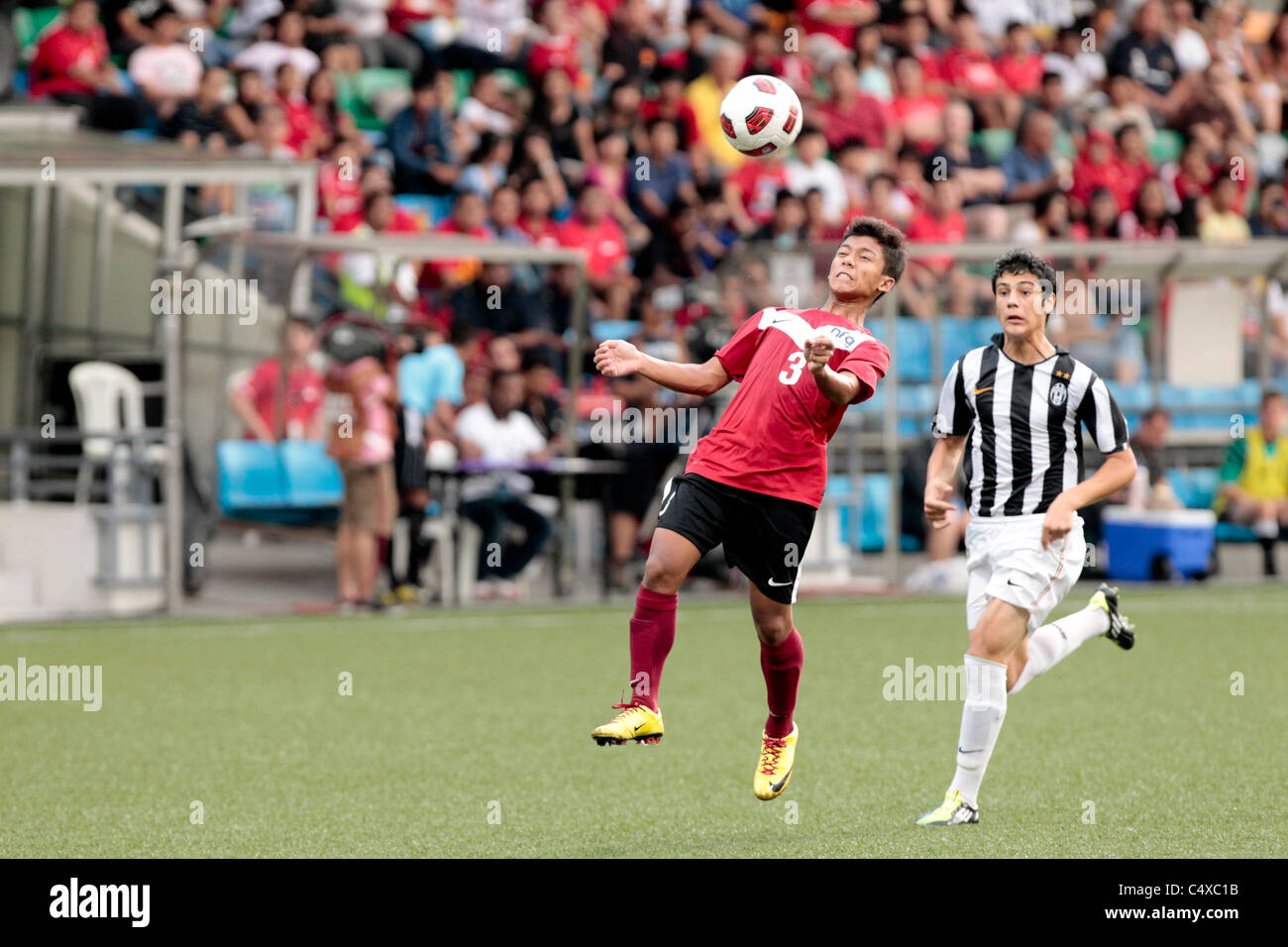 Mahathir Azeman of Singapore U15(red) heads the ball back to the ...