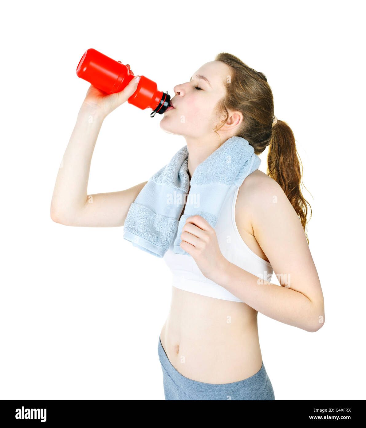 Happy fit young woman drinking from water bottle after workout Stock Photo