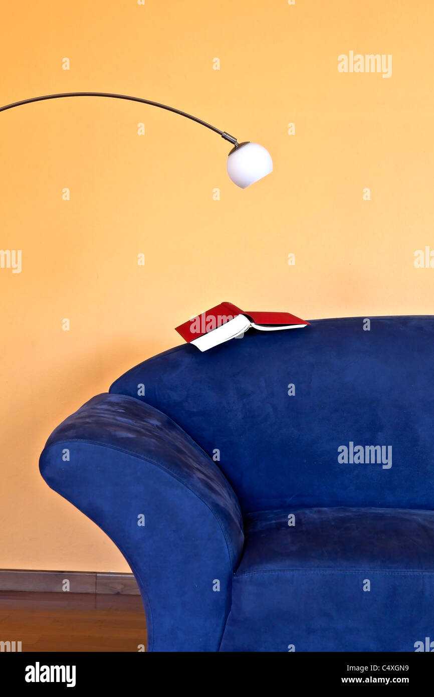 a reading corner with a blue couch, a book and a reading lamp Stock Photo